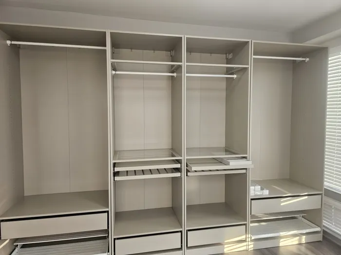 Fitted closet system with hanging rails, shelves and drawers installed