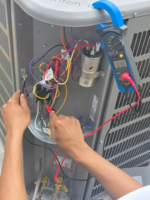 Testing wiring inside an opened condensing unit with a clamp meter