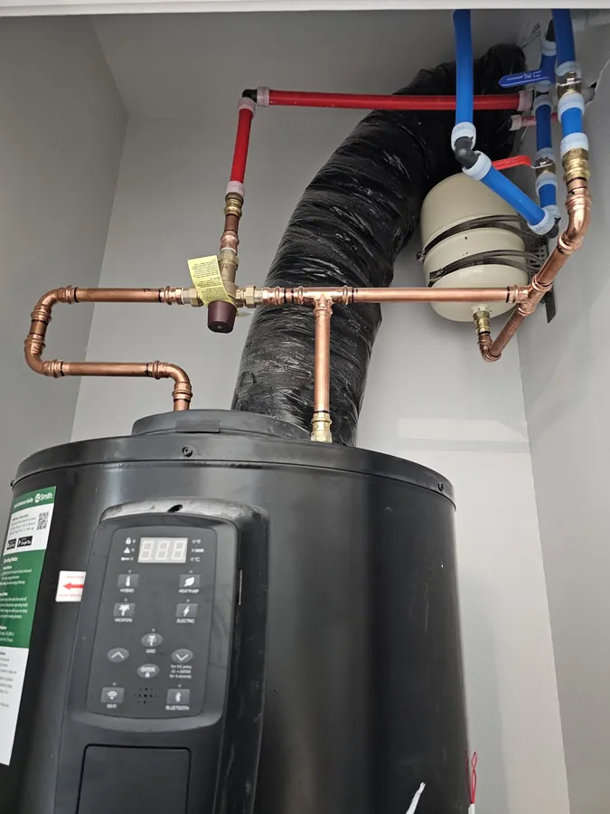 New water heater installed with freshly soldered copper pipework above it