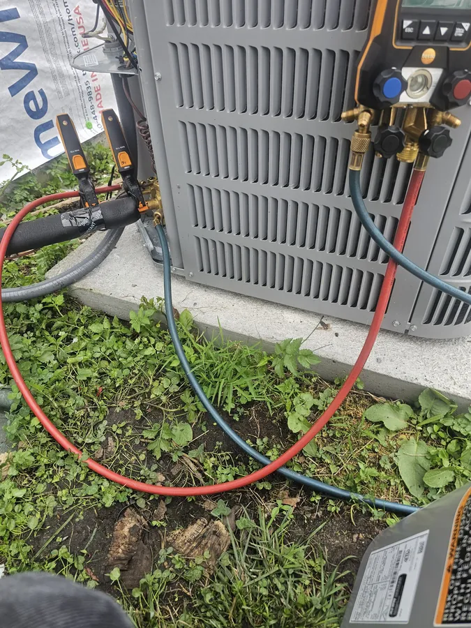 Refrigerant manifold gauges connected to an outdoor condensing unit